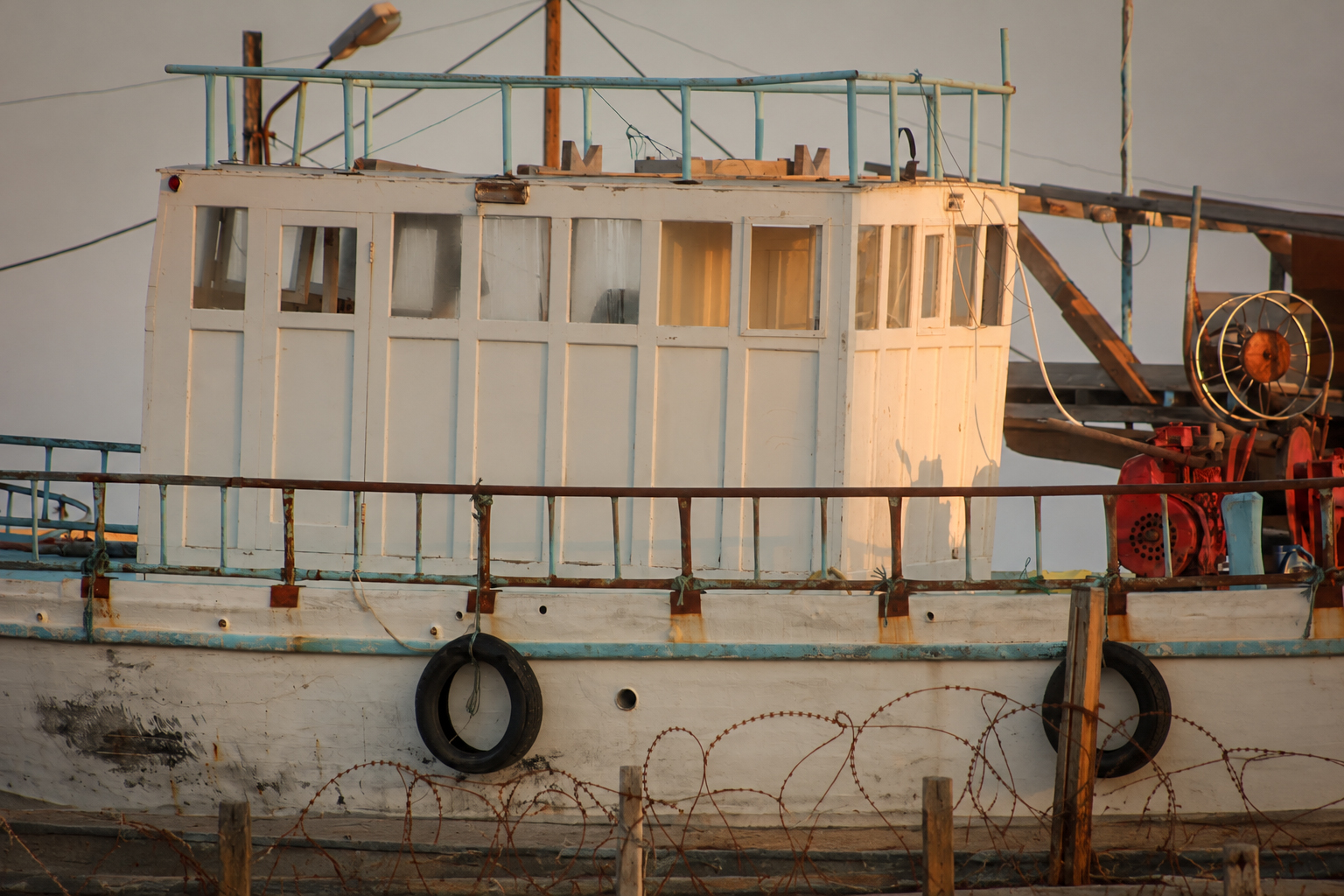 Un bateau de pêche blanc et sa timonerie, amarré au quai