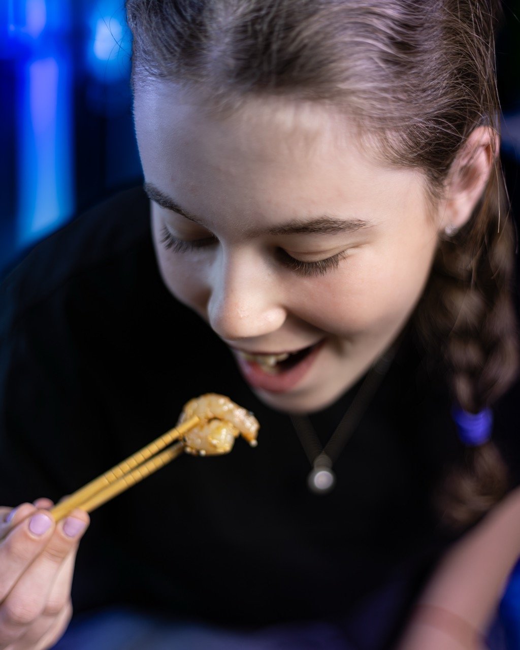 Personne dégustant un bol de cuisine fusion avec des baguettes